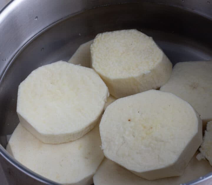 Peeled African yam slices in a pot covered with water