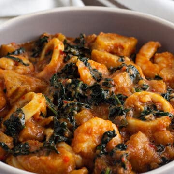 Green plantain porridge with seafood on a grey plate