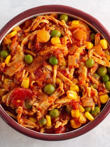 Peri peri shredded chicken with vegetables in a bowl.