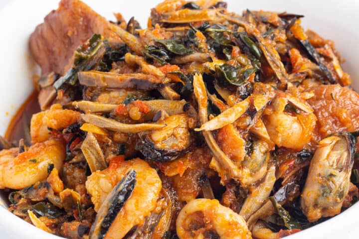Ugba/Ukpaka (African oil bean seed) sauce with smoked turkey, seafood and kale