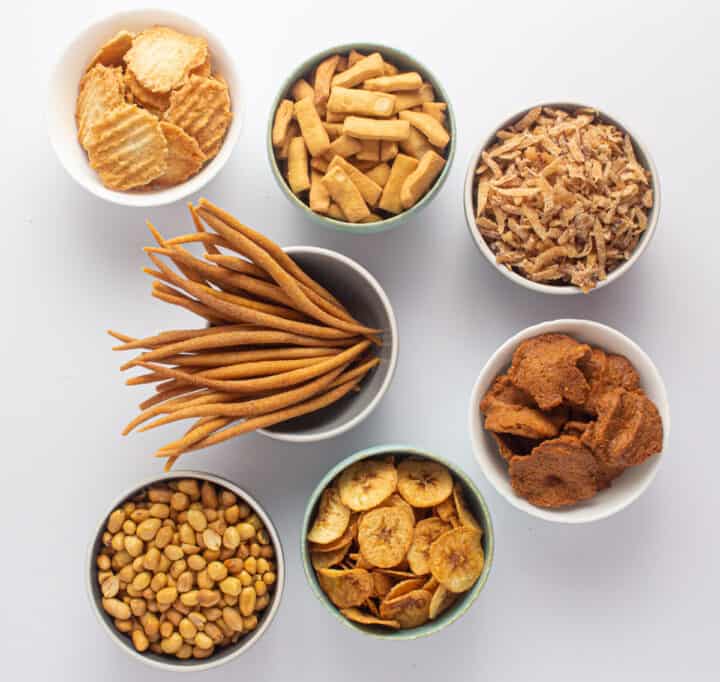 A selection of Nigerian snacks - kokoro, kulikuli, chinchin, plantain chips, roasted groundnut, gurundi and coconut candy