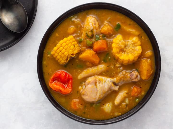 Jamaican chicken soup with spinners in a black bowl