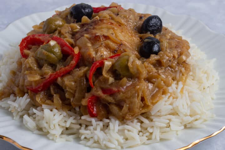 Chicken yassa served on a bed of white rice.