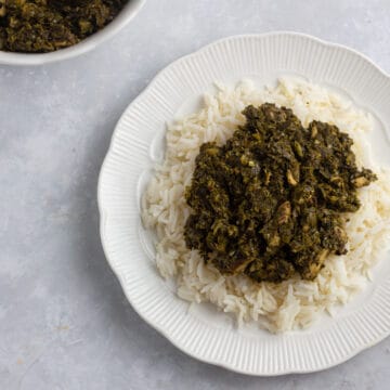 Cassava leaves soup (pondu) - served over rice on a white plate