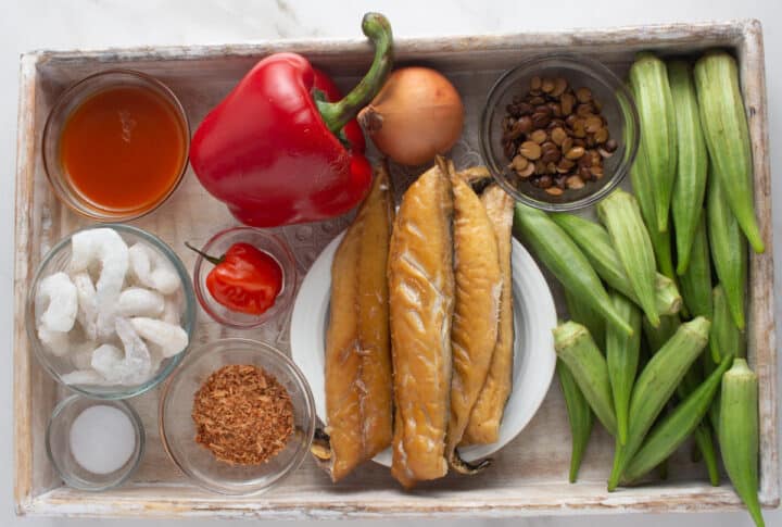 Ingredients for Nigerian Okra soup arranged on a wooden tray